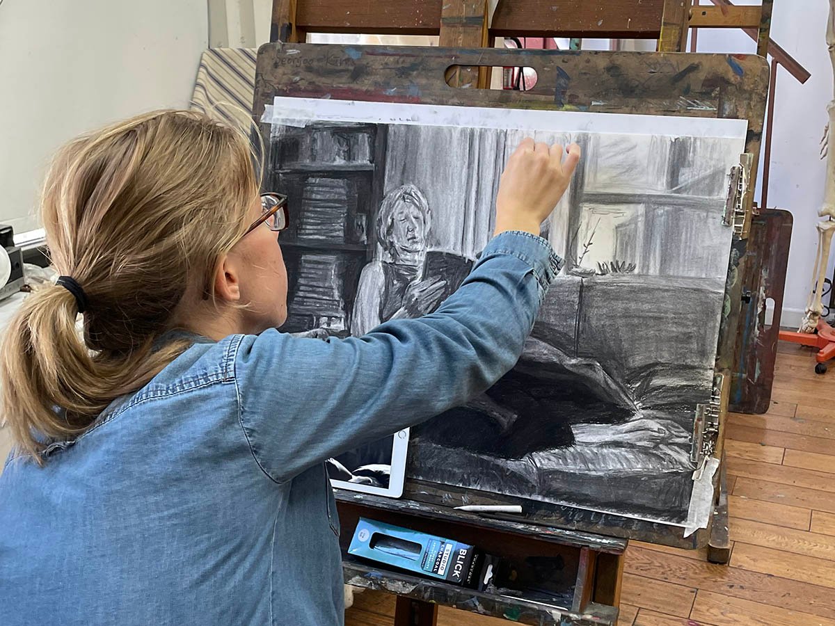 Adult student practicing painting techniques on canvas in NYC art class