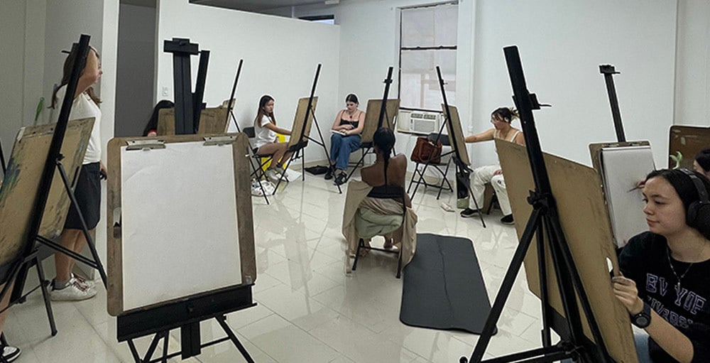 Students working at easels in a structured art class environment at New York Art Studio in New York City