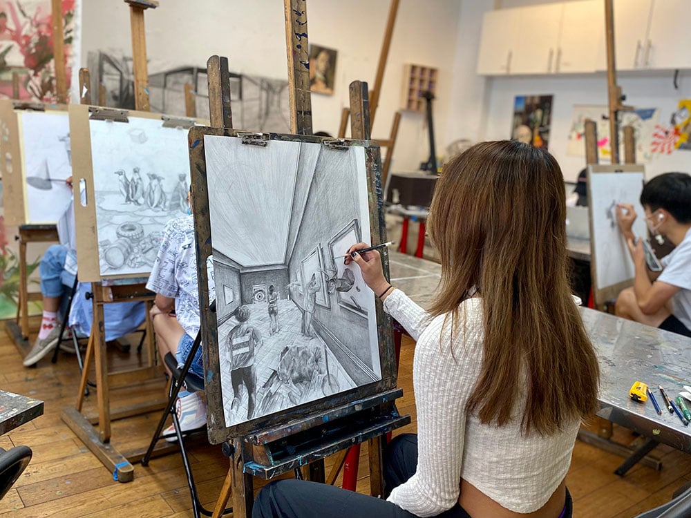 Student developing artwork for art competition portfolio preparation in NYC studio