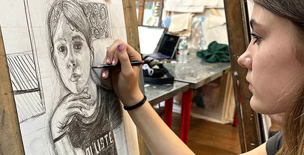 Art high school portfolio preparation program at New York Art Studio in NYC with student drawing in studio