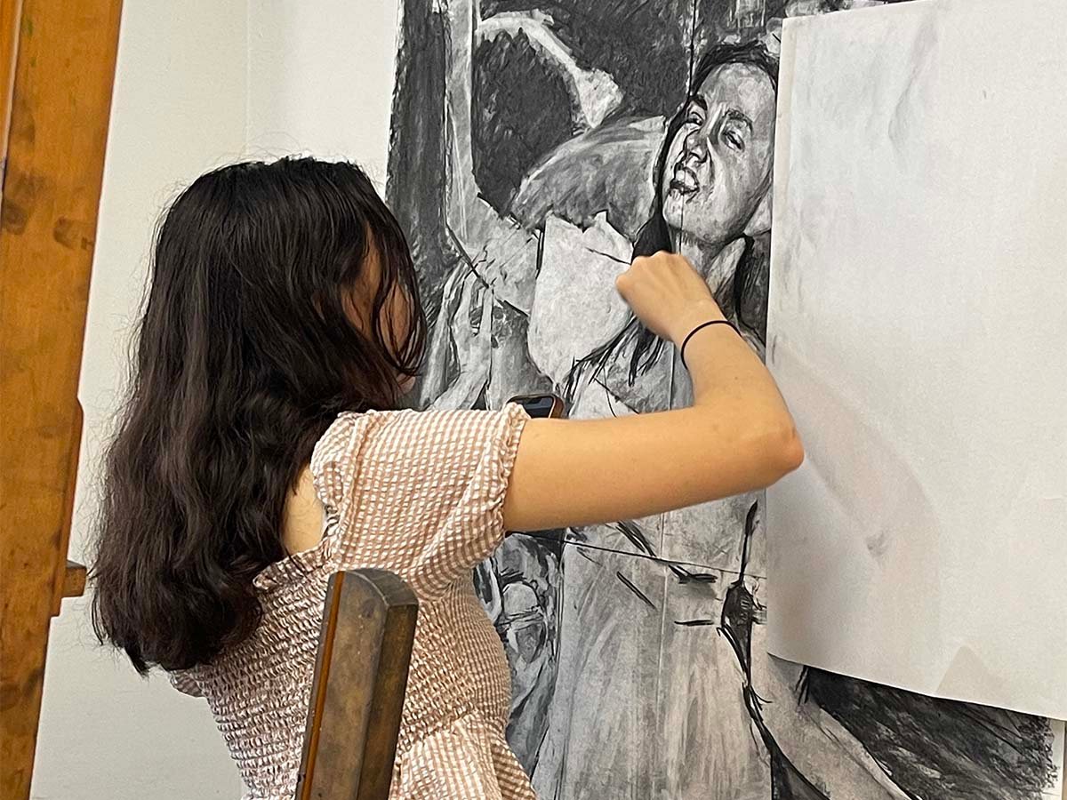 Student working on large drawing in college portfolio prep class at New York Art Studio