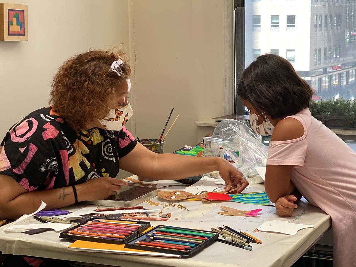 Child painting on canvas and exploring creative expression in an art class in New York